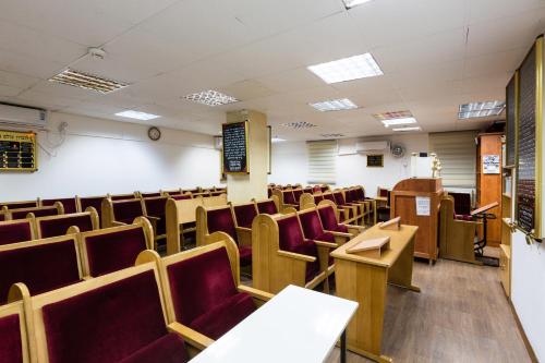 an empty classroom with red chairs and desks at מלון המלך שאול in Ashqelon