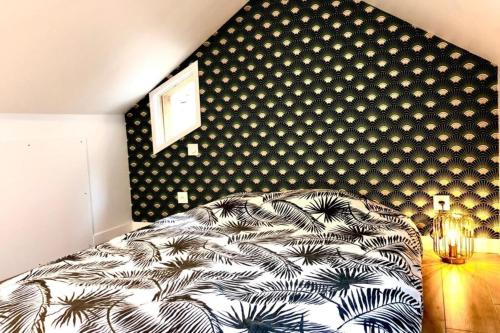 ein Schlafzimmer mit einem Bett und einer schwarz-weißen Wand in der Unterkunft Suites Rive Gauche - DUPLEX CHARME Fontainebleau in Fontainebleau