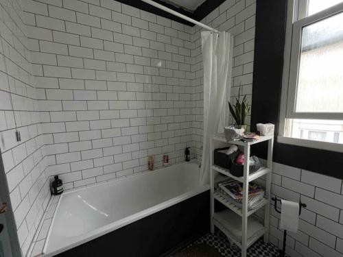 a white bathroom with a tub and a window at Town House in the North Laines in Brighton & Hove