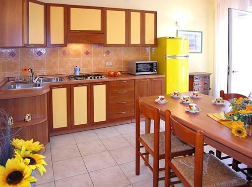 ビビオーネにあるCasa Vacanze Azaleaのキッチン(木製テーブル、椅子付)、キッチン(シンク付)