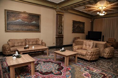 a living room with couches and tables and a television at Bey Hotel Baku in Baku
