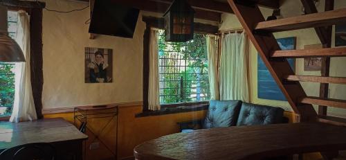 una sala de estar con una silla de cuero azul y ventanas en Cabañas Arenas del Faro en Mar del Plata