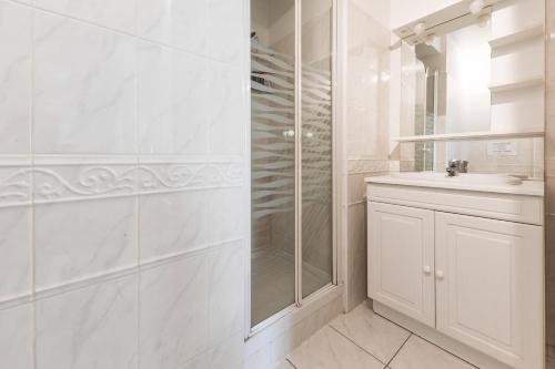 baño blanco con ducha y lavamanos en Vacances iodees a Sarzeau, en Sarzeau
