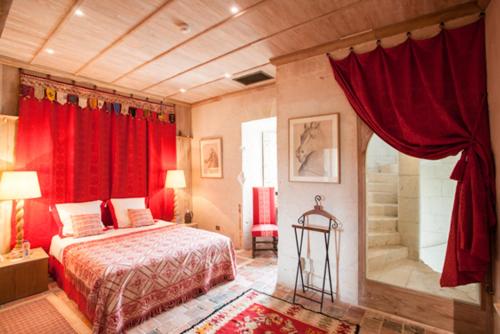 - une chambre avec des rideaux rouges, un lit et une douche dans l'établissement Hôtel du Château du Rivau, à Lémeré
