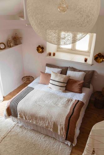 une chambre avec un lit avec des oreillers et une fenêtre dans l'établissement Maison Bellamant, à Alan