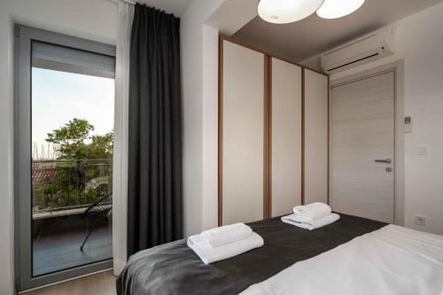 una camera con un letto e una grande finestra di Apartments in Vrsar - Istrien 47120 a Vrsar