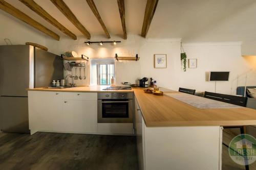a kitchen with white cabinets and a wooden counter top at Casitalonga - NEW studio apartment in Sayalonga in Sayalonga