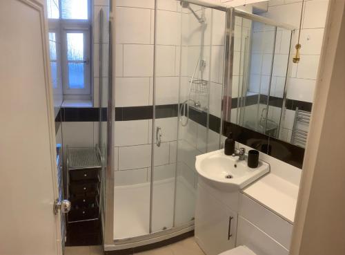 a white bathroom with a sink and a shower at CENTRAL LOCATION! Double Bedroom 2 Mins Walk from Battersea Power underground Station! in London