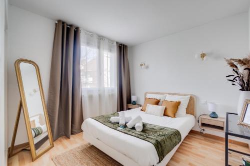 une chambre avec un lit blanc avec un miroir dans l'établissement Élégance, charme et confort, à Toulouse