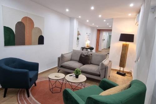 een woonkamer met een bank en 2 stoelen bij Apartamento Entero Juzgados Alicante in Alicante