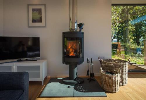 a living room with a wood burning stove in a living room at Stalker's Lodge in Perth