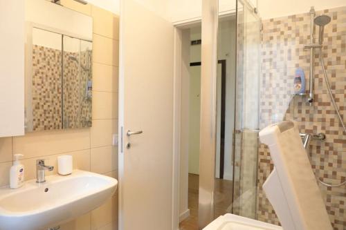 a bathroom with a sink and a glass shower at Ampio bilocale in centro con parcheggio gratuito nella proprietà, vicino a stazione Como-Milano in Erba