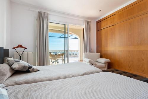 een slaapkamer met 2 bedden en uitzicht op de oceaan bij VILLA BENDINAT 10 in Calvia Town