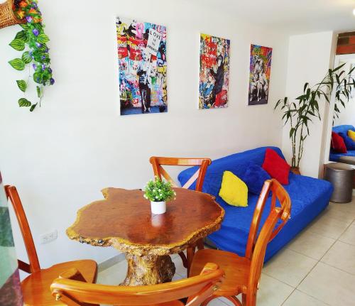 een woonkamer met een tafel en een blauwe bank bij Orquidia 12 in Salento