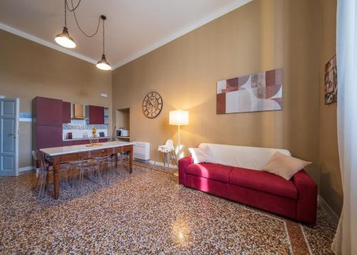 a living room with a red couch and a table at Lungarno Buozzi 7 Apartments in Pisa