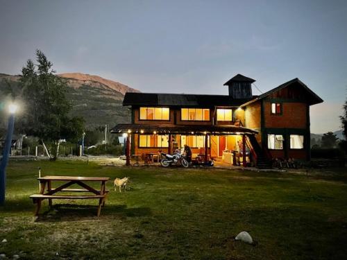 a house with a picnic table in front of it at Hostal del río in El Bolsón