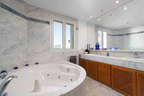 a large bathroom with a tub and two sinks at Villa Bendinat 10 in Calvia Town