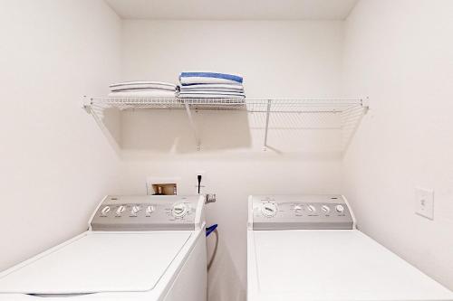 eine weiße Waschküche mit Waschmaschine und Trockner in der Unterkunft Sunshine State Delight in Middleburg