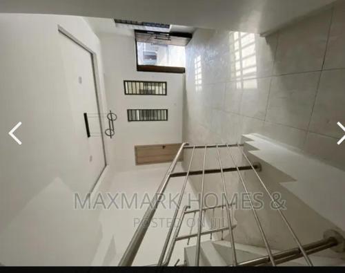 a room with a staircase and a white wall at Emmatuxz Properties in Lagos
