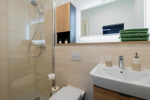 La salle de bains est pourvue d'un lavabo, de toilettes et d'une douche. dans l'établissement Jade&Jabo - Moderne möblierte Serviced Apartments - Düsseldorf-Neuss, à Neuss