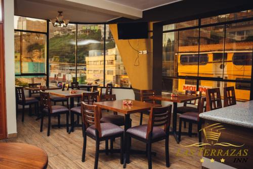 un restaurant avec des tables et des chaises et un bus sous la fenêtre dans l'établissement HOTEL LAS TERRAZAS INN, à Andahuaylas