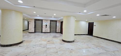 an empty room with columns in a building at فندق إي دبليو جي النزهة متوفر توصيل مجاني للحرم in Mecca