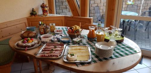 stół z jedzeniem i napojami na górze w obiekcie Cafe & Pension Carmen w mieście Brotterode