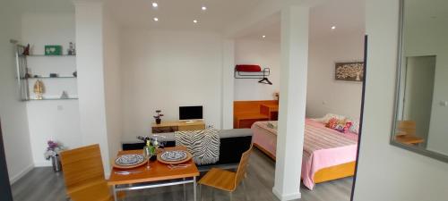 a bedroom with a bed and a table and a desk at Vista Funchal Ⅰ in Funchal