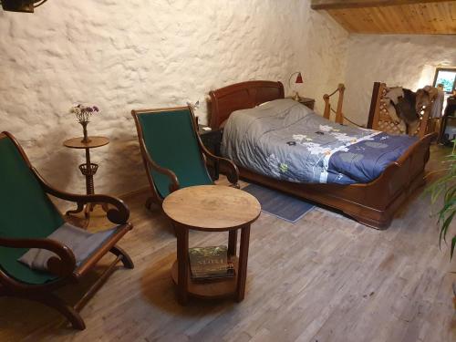 1 dormitorio con 1 cama, mesa y sillas en Chambre d’hôtes de Vauguenige, en Saint-Pardoux