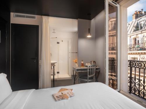 a bedroom with a bed and a balcony at Grand Hotel Lafayette in Paris