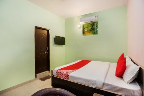 BahoraにあるFlagship Park Hotelのベッドルーム1室(赤と白の枕が備わるベッド1台付)
