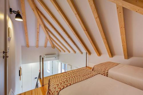Kleines Zimmer mit einem Bett und Holzdecken. in der Unterkunft Cais das Pedras Duplex by Cozy Stay in Porto