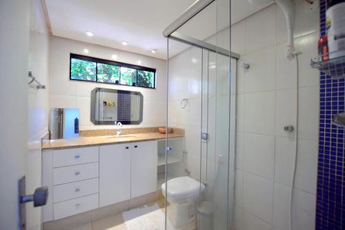 uma casa de banho com um WC e uma cabina de duche em vidro. em Chalé Lago Norte em Brasília