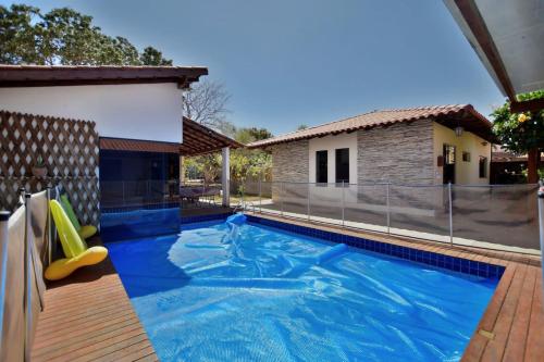 a swimming pool with a slide and a house at Chalé Lago Norte in Brasilia