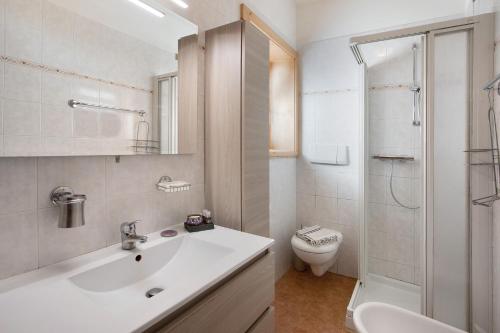 Mountain Apartments Livigno في ليفينو: حمام أبيض مع حوض ومرحاض
