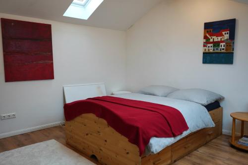 a bedroom with a wooden bed with a red blanket at Charmantes Maisonette-Appartment in Cologne
