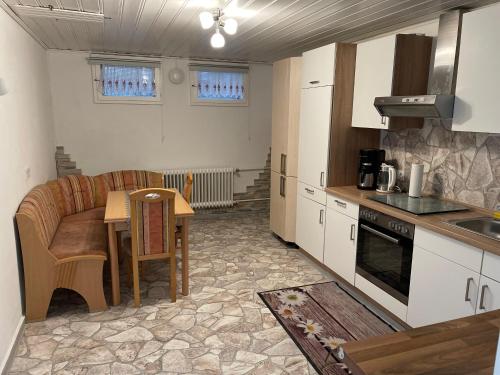 a kitchen with a table and a couch in it at Schöne Ferienwohnung in Lehrberg