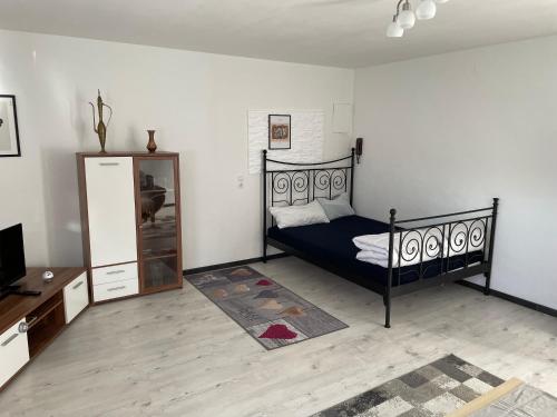 a bedroom with a black bed and a dresser at Schöne Ferienwohnung in Lehrberg