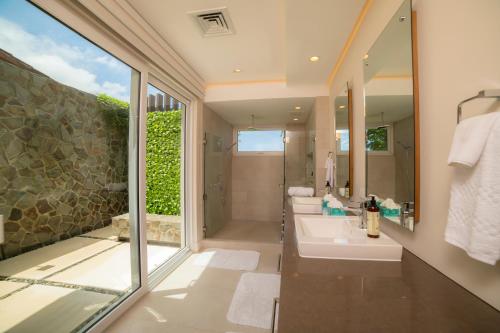 a bathroom with a shower and a sink and a mirror at Casa Blue Sail 6 bdrs ocean view in Los Suenos in Herradura