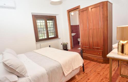 a bedroom with a bed and a wooden cabinet at Casale del Passatore sas in Rocchette