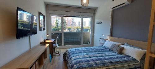 聖塞巴斯蒂安德洛斯雷耶斯的住宿－Studio Europa 30，一间卧室配有一张床、一张书桌和一个窗户。