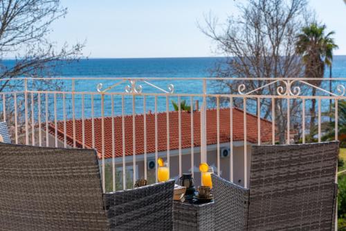 a balcony with two chairs and a view of the ocean at Southbank seafront apartments in Katelios