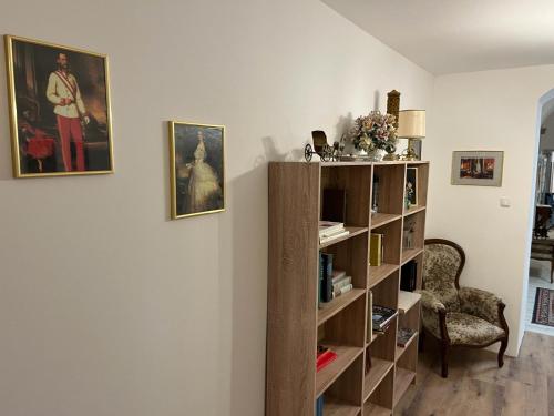 a living room with a book shelf and a chair at City Hotel Post 11 in Braunau am Inn