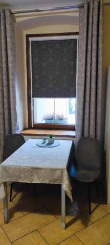 a table and two chairs in a room with a window at Śmieszek in Stronie Śląskie