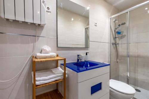 a bathroom with a blue sink and a shower at Dúplex 2 plantas en Madrid Cuzco - Plz Castilla - Home Sweet Home in Madrid