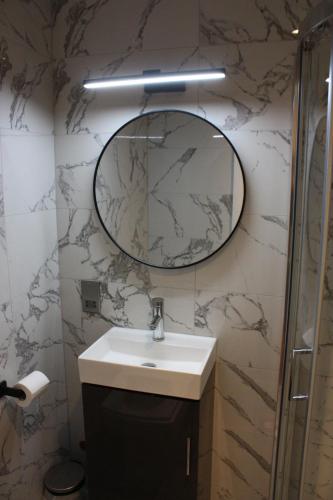 ロンドンにあるホテル オリンピアのバスルーム(洗面台、壁掛け鏡付)