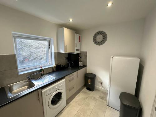 a kitchen with a sink and a washing machine at 3 bed Hackney/Harringay Flat in London