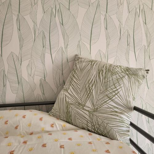 a bed with a pillow and a wall at GILMORE Home - close to PARIS center in La Courneuve