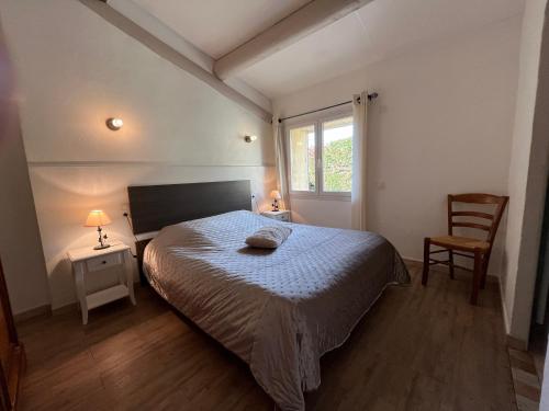 une chambre avec un lit, une chaise et une fenêtre dans l'établissement LE MAS PROVENCAL, à Vaison-la-Romaine