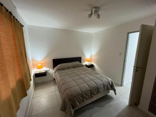 1 dormitorio con 1 cama y 2 lámparas en 2 mesas en Del Camino. Hospedaje Temporal en Zapala